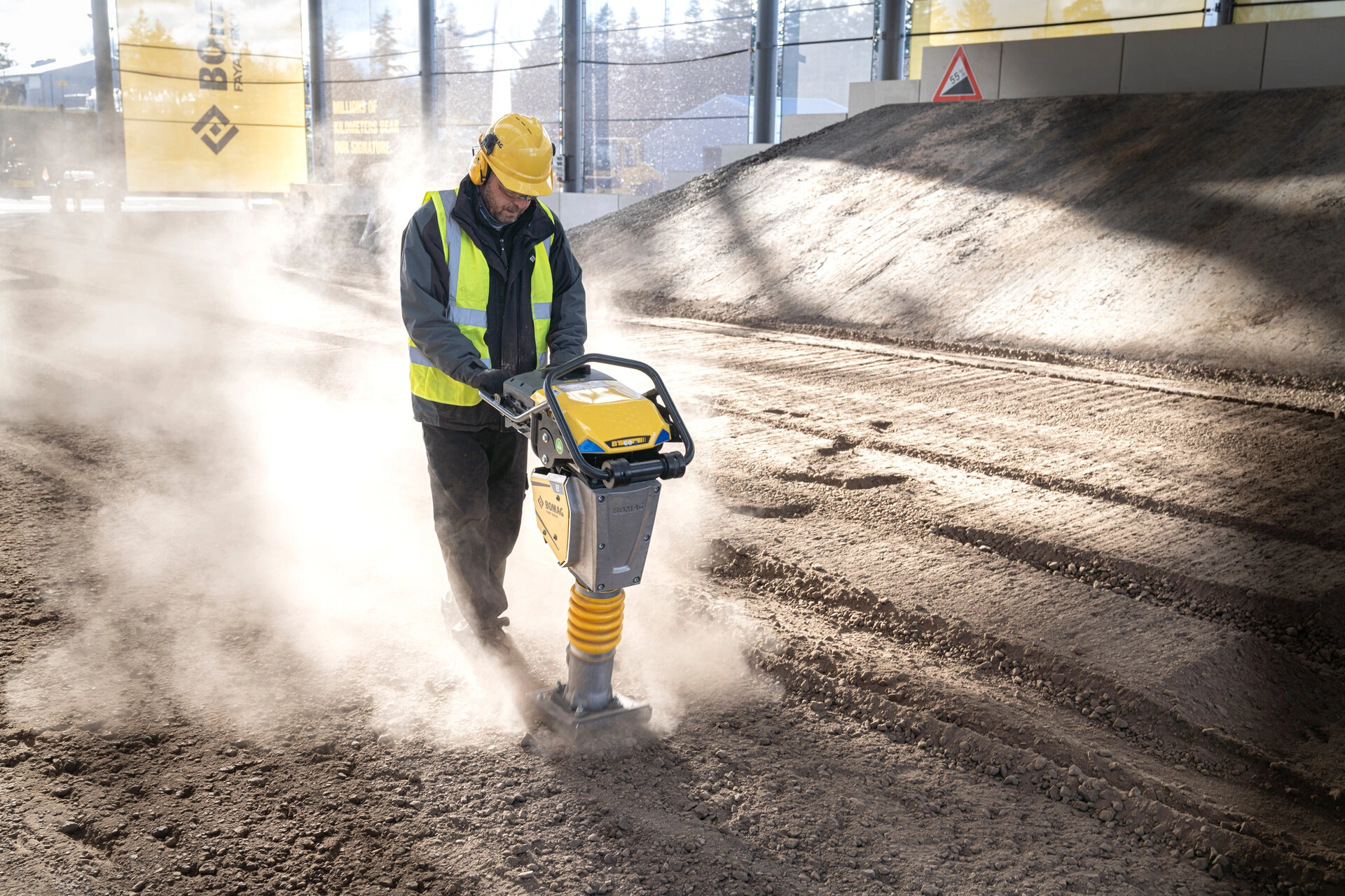 Komatsu bandgrävare gräver jord bredvid en väg