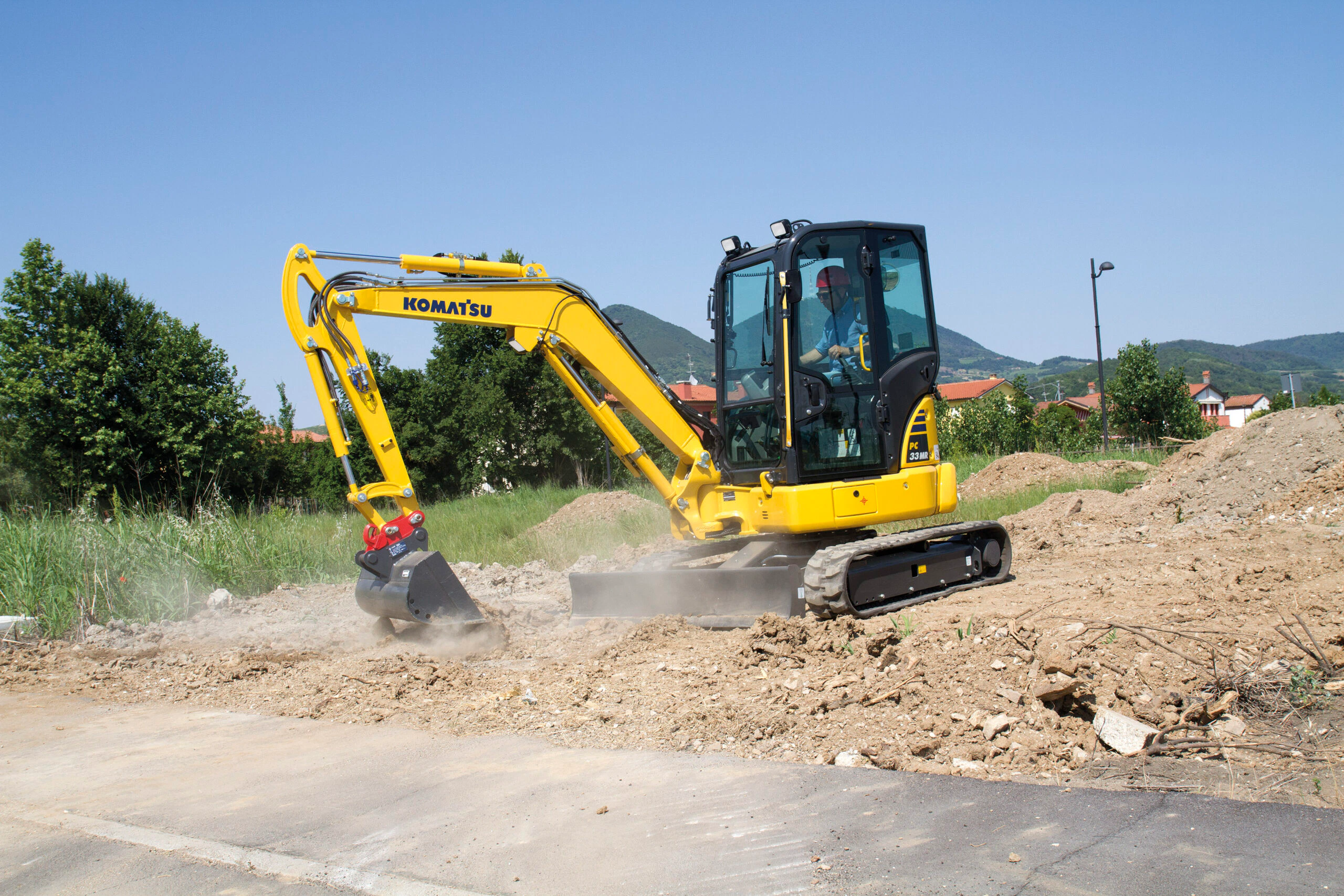 Komatsu PC38MR-5 gräver bredvid en väg