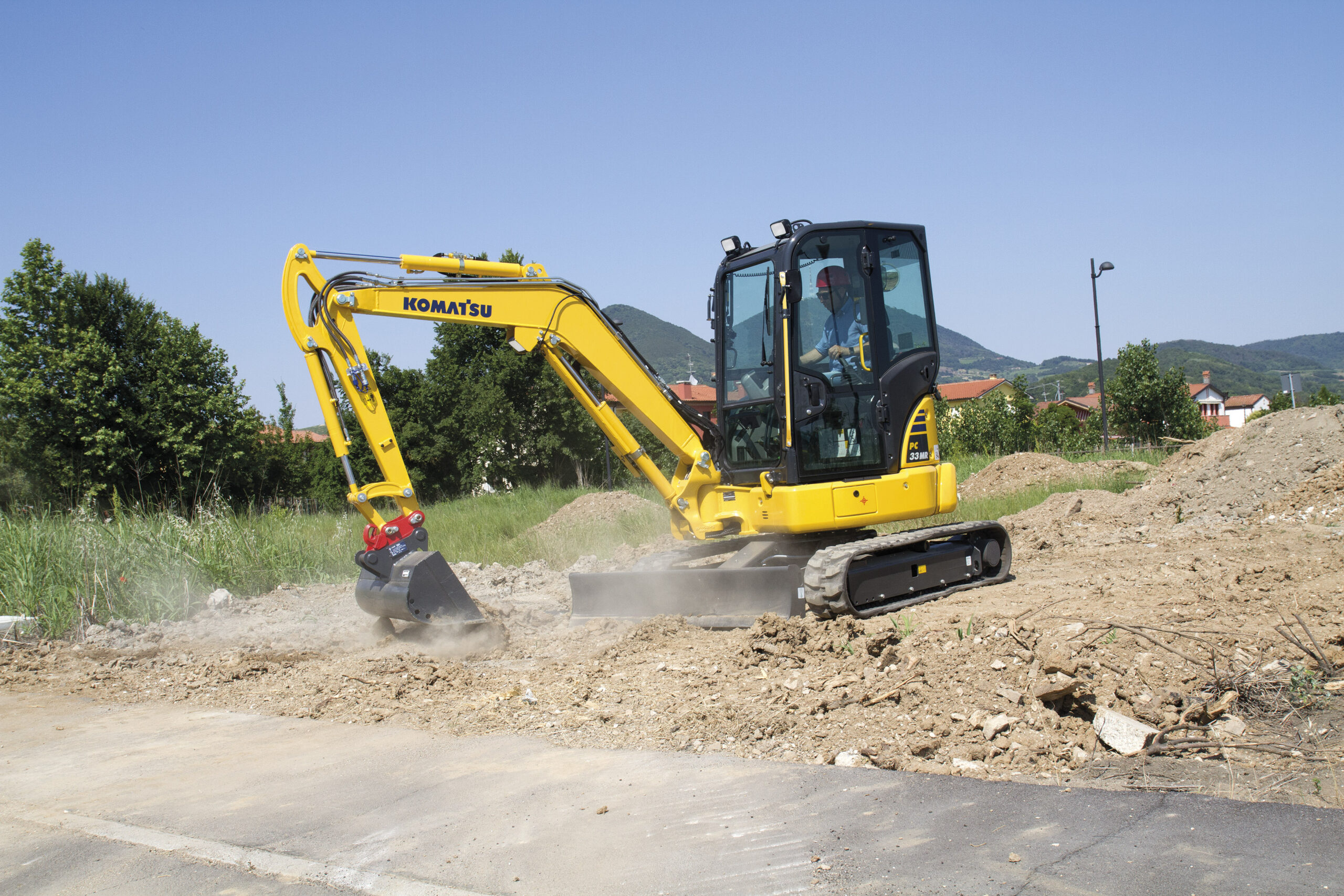 Komatsu PC38MR-5 gräver bredvid en väg